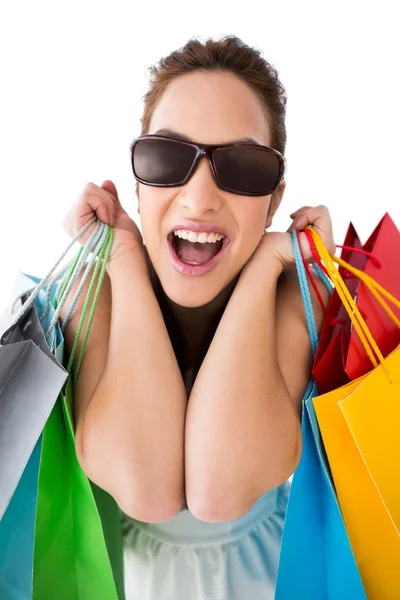 Portrait of excited brunette with sunglasses holding shopping ba — Stock Photo, Image