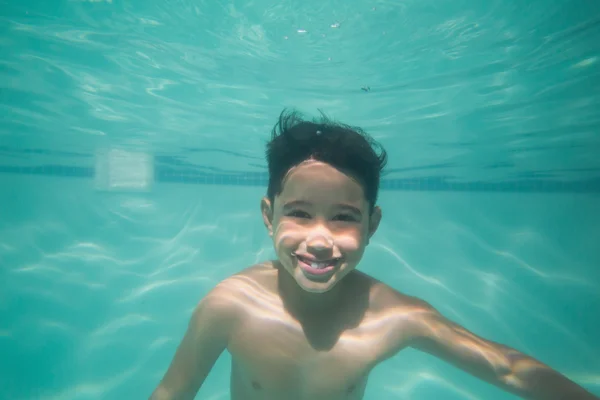 Niño lindo posando bajo el agua en la piscina — Foto de Stock