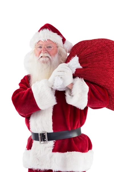 Санта носит свою красную сумку и улыбается — стоковое фото