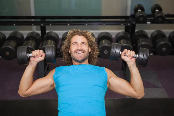 Homme faisant de l'exercice avec haltères dans la salle de gym — Photo