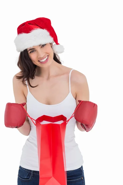 Festive brunette in boxing gloves opening shopping bag — Stock Photo, Image