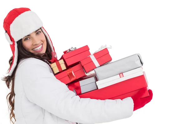 Festive brunette in winter clothes holding many gifts — Stock Photo, Image