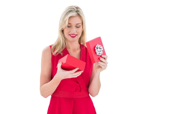 Stylish blonde in red dress opening gift box — Stock Photo, Image