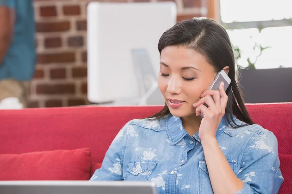 Mulher usando laptop e telefone celular — Fotografia de Stock