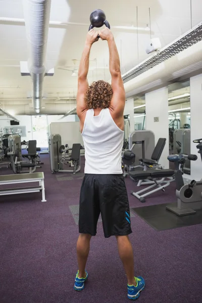 Hombre levantando la campana de la tetera en el gimnasio — Foto de Stock