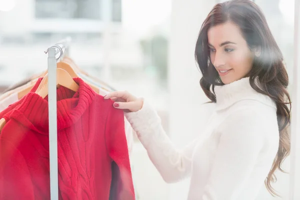 Bonita morena mirando ropa en riel — Foto de Stock