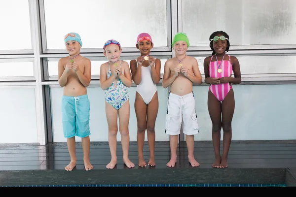 Niños de pie junto a la piscina con medallas —  Fotos de Stock