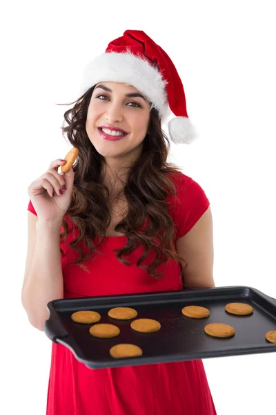 Праздничная брюнетка ест горячее печенье — стоковое фото