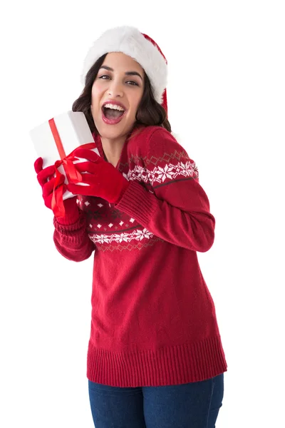 Excited brunette showing christmas present — Stock Photo, Image