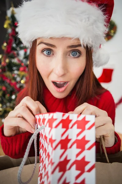 Festive redhead opening christmas gift — Stock Photo, Image