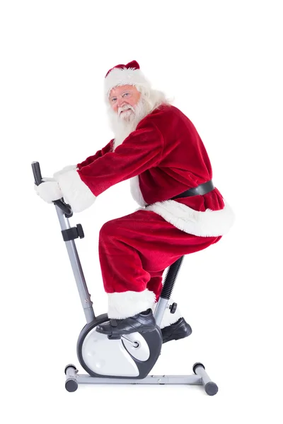 Santa benutzt einen Heimtrainer — Stockfoto