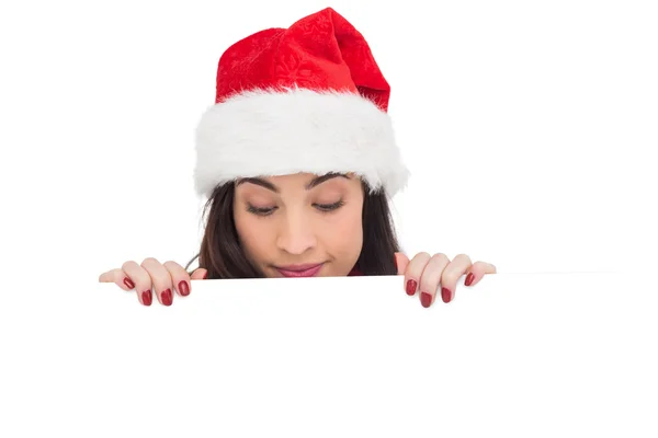 Bella bruna in cappello di Babbo Natale mostrando poster bianco — Foto Stock