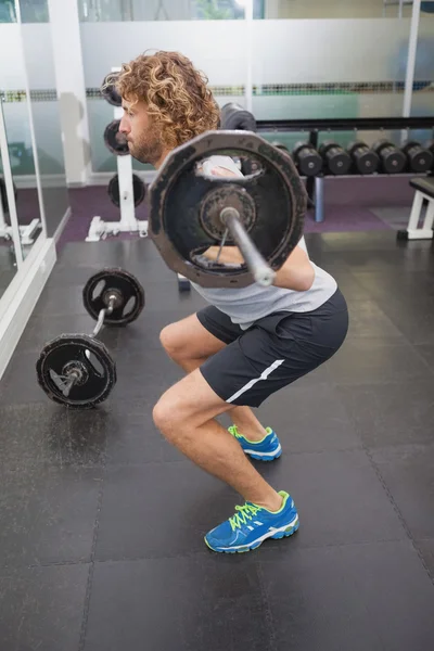 Uomo che solleva il bilanciere in palestra — Foto Stock