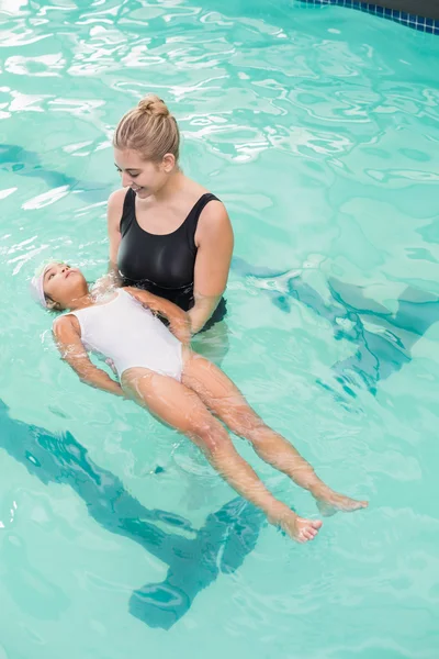 Schattig klein meisje leren om te zwemmen met coach — Stockfoto