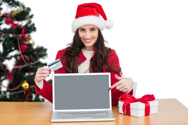 Feestelijke brunette wijzen scherm en online winkelen met laptop — Stockfoto