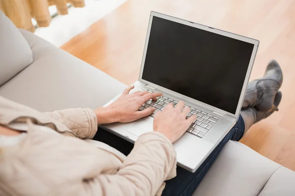 Blonde woman using laptop on couch — Stock Photo, Image