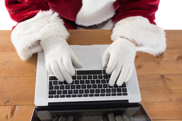 Santa está escribiendo algo en su portátil —  Fotos de Stock