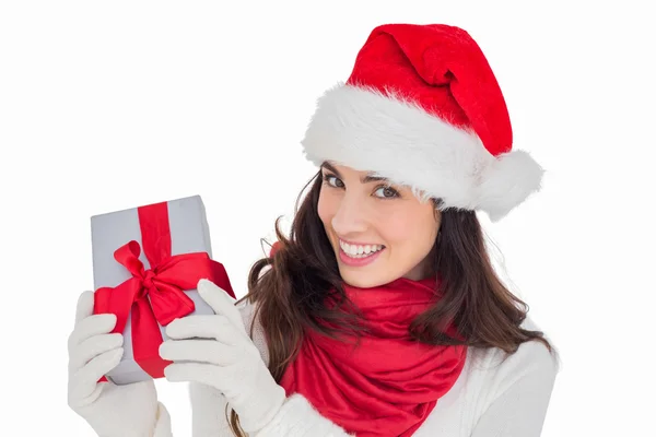 Eccitato bruna in cappello di Babbo Natale mostrando regalo — Foto Stock