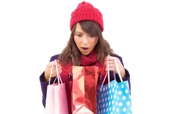 Shocked brunette opening gift bag — Stock Photo, Image