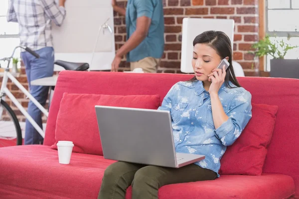 Woman using laptop and mobile phone — Stok fotoğraf