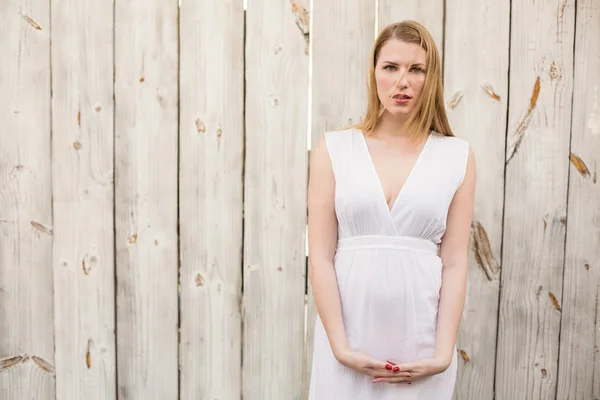 Elegant blonde woman standing while looking at camera — Stock Photo, Image