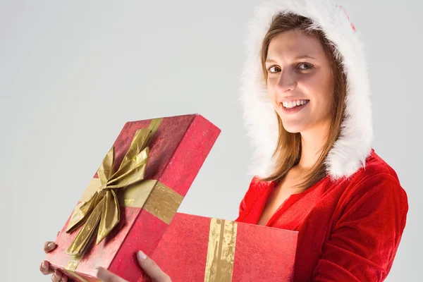 Lächelndes Mädchen, das ein Geschenk öffnet und in die Kamera blickt — Stockfoto