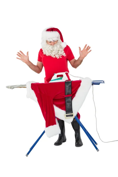 Surprised santa claus ironing his jacket — Stock Photo, Image