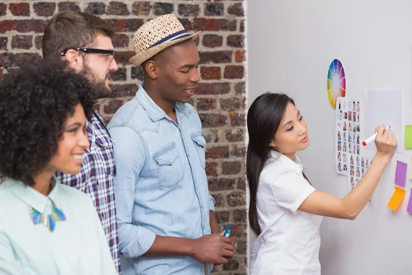 Team kijken naar kleverige nota's op de muur — Stockfoto