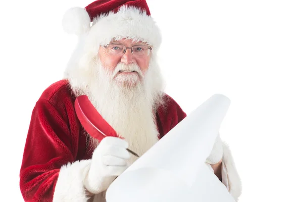 Santa escribe algo con una pluma — Foto de Stock