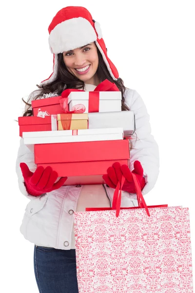 Morena en ropa de invierno sosteniendo muchos regalos y bolsas de compras — Foto de Stock