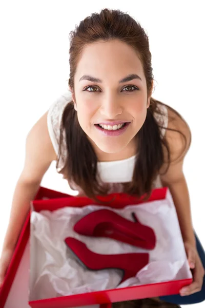 Gelukkig brunette bedrijf aanwezig zijn met schoenen — Stockfoto