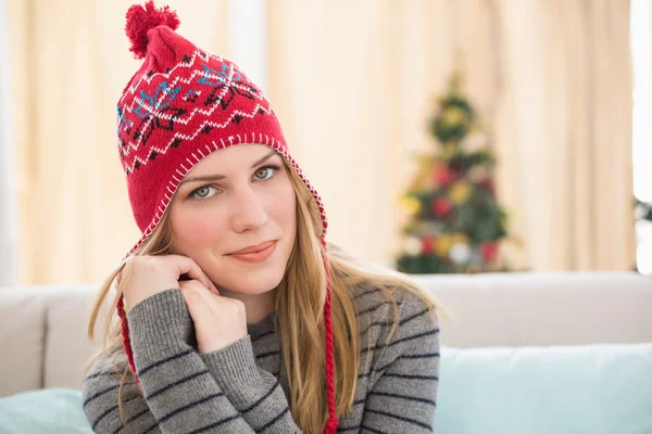 Hübsche Blondine in Winterkleidung sitzt auf der Couch — Stockfoto