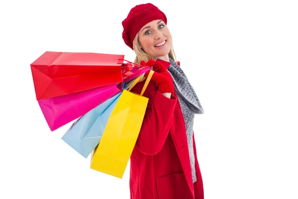 Blonde in winter kleding bedrijf shopping tassen — Stockfoto