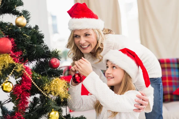 Festlig mor och dotter dekorera julgran — Stockfoto