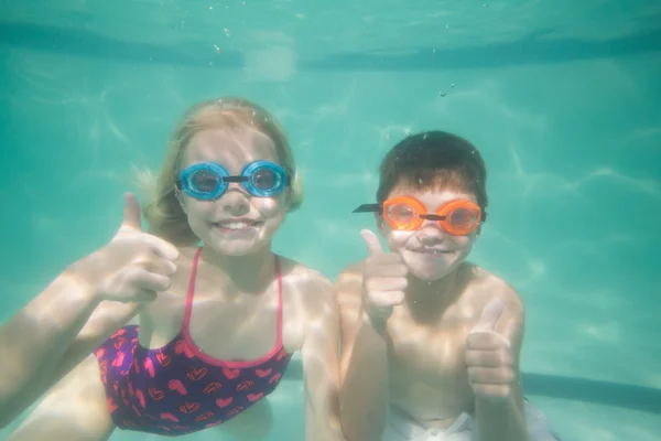 Bonito crianças posando debaixo d 'água na piscina — Fotografia de Stock