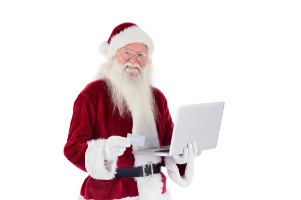 Santa πληρώνει με πιστωτική κάρτα σε έναν φορητό υπολογιστή — Φωτογραφία Αρχείου