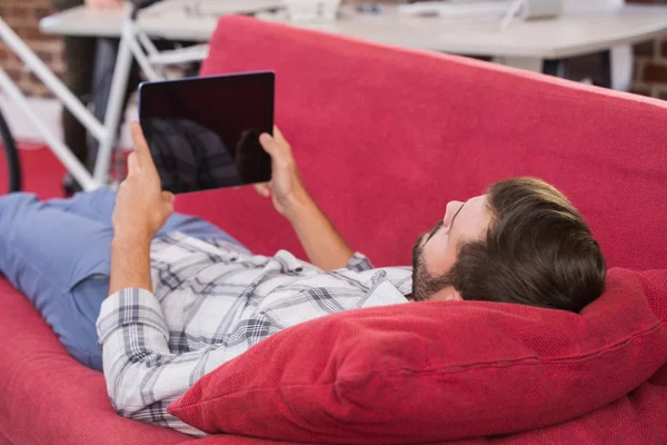 Homem usando tablet digital no sofá — Fotografia de Stock