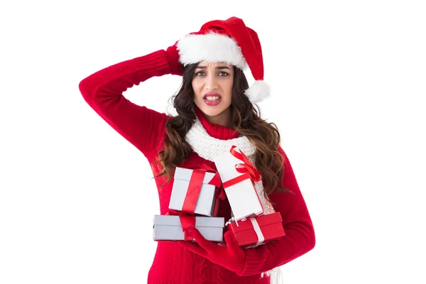 Stressed brunette in santa hat holding gifts — Stock Photo, Image