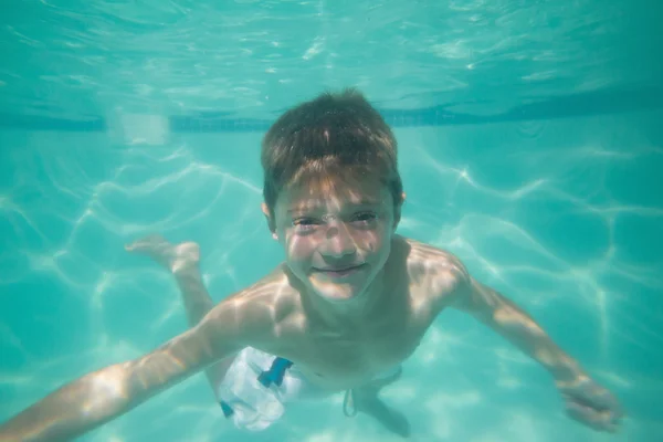 Niño lindo posando bajo el agua en la piscina — Foto de Stock