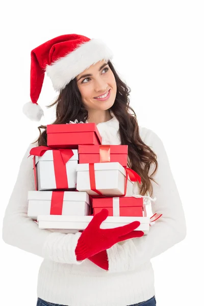 Vrolijke brunette in santa hat en rode handschoenen houden stapel voor gift — Stockfoto