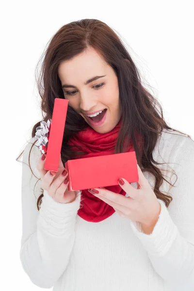 Surprised brunette opening christmas gift — Stock Photo, Image