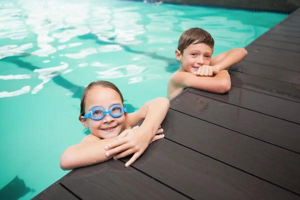 Kleine Geschwister lächeln im Pool — Stockfoto