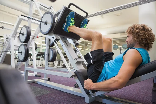 Hombre haciendo prensas de piernas en el gimnasio — Foto de Stock