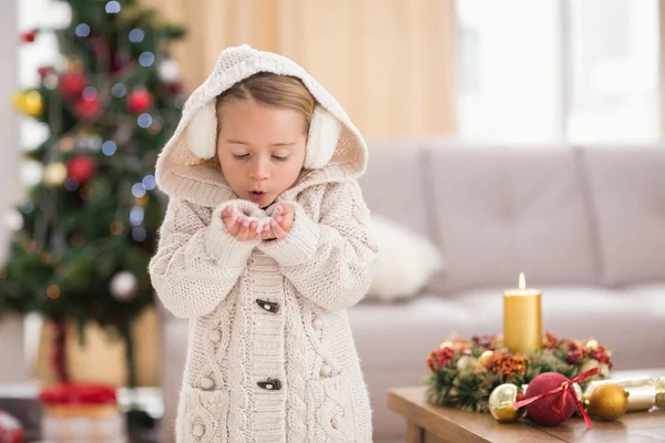 Festlig liten flicka blåser över händerna — Stockfoto