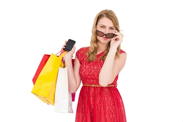 Mujer linda sosteniendo bolsas de compras y su teléfono inteligente — Foto de Stock