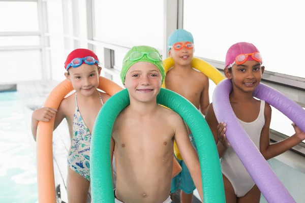 Kids standing poolside with foam rollers — Stock Photo, Image