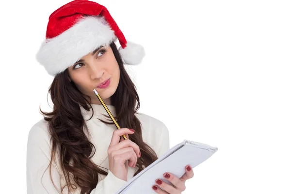 Festive brunette thinking about her christmas list — Stock Photo, Image