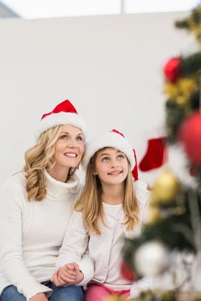 Mãe festiva e filha sorrindo para a árvore — Fotografia de Stock