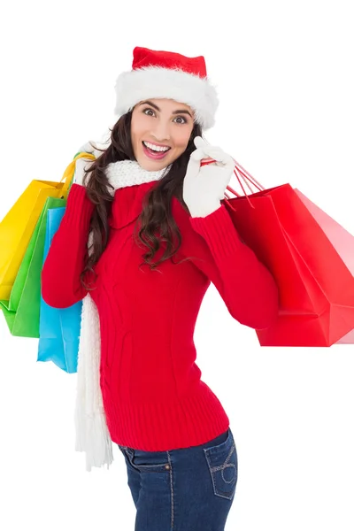 Feestelijke brunette in winter slijtage houden shopping tassen Stockfoto