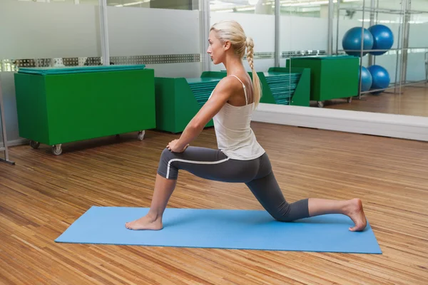 Adatta donna che fa esercizio di stretching in palestra — Foto Stock